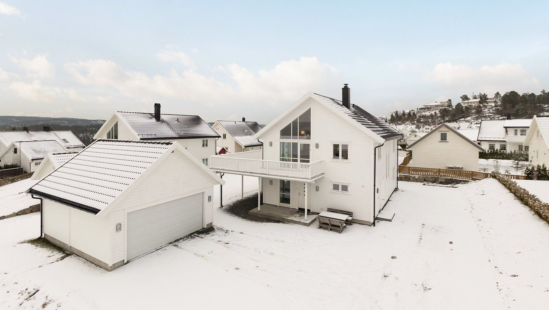 Hvit moderne bolig med garasje om vinteren
